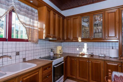 a kitchen with wooden cabinets and a sink at Andreas House in Valíra