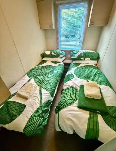 a room with four beds with green leaves on them at St Tropez Surprise in Gassin