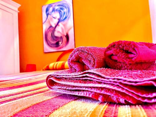a pile of pink towels sitting on top of a bed at Beautiful apartment surrounded by greenery in Chiaramonti