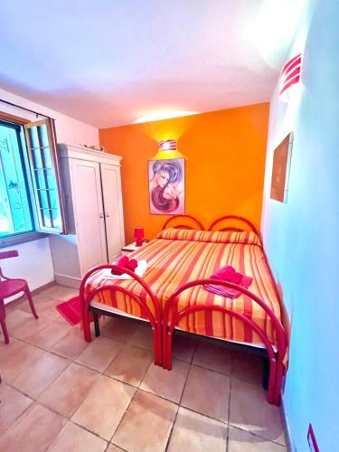 a bedroom with a bed with an orange wall at Beautiful apartment surrounded by greenery in Chiaramonti