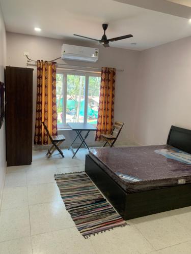 a living room with a bed and a table at Aasra Studios in Agonda