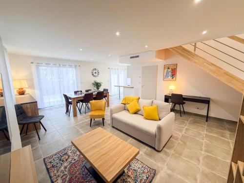 a living room with a couch and a table at Les oiseaux, maison de 3 chambres et climatisation in Montauban
