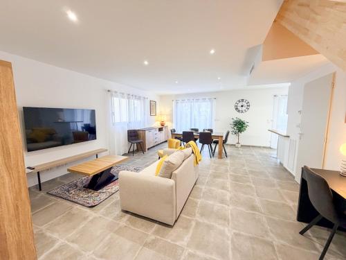 a living room with a couch and a tv at Les oiseaux, maison de 3 chambres et climatisation in Montauban