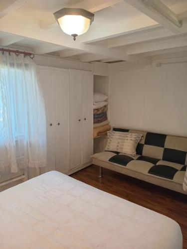 a bedroom with a bed and a couch in a room at Apartamento Villa Amanecer in Villarrica