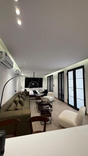 a living room with couches and tables and windows at Wadi Hanifa View وادي حنيفة ڤيو in Riyadh