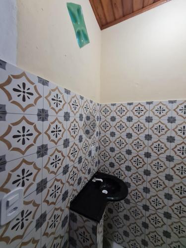a bathroom with a sink and tiles on the wall at Studio - Casa da Restinga in Cabo Frio