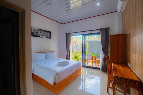 a bedroom with a bed and a view of a patio at Sundara Haven in Ungasan