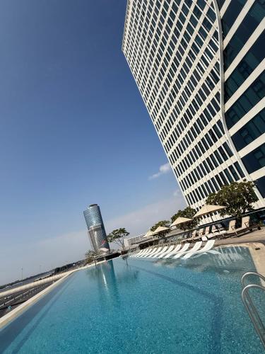 a swimming pool in front of a tall building at Capital Suites Hotel Apartments in Abu Dhabi