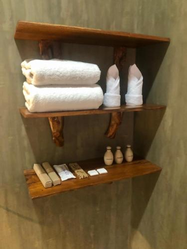 a wooden shelf with towels and books on it at Nature Luxe Sigiriya in Sigiriya