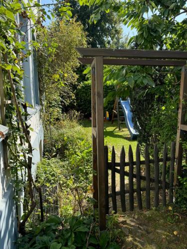 a wooden gate in a garden with a playground at Ferienwohnung Birklund in Probsteierhagen