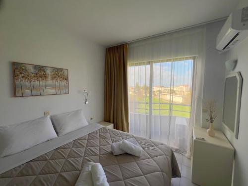 a bedroom with a bed and a large window at Ivory Serenity in Theologos