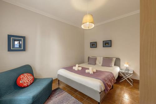 a bedroom with a bed and a blue couch at Ferrel Dreams in Ferrel