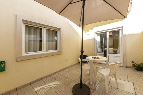 a white table and chairs with an umbrella at Ferrel Dreams in Ferrel