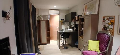 a living room with a desk and a table and chairs at Studio clim 4-5 pers animaux, mai oct spa et piscine in Saint-Ambroix