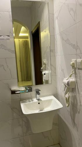 a bathroom with a white sink and a mirror at شقق مخدومه in Ash Shafa
