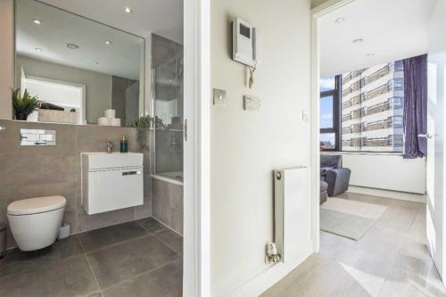 a bathroom with a toilet and a sink and a mirror at Heathrow Retail Park Aprt Sleeps SEVEN Turbo WiFi in Sunbury Common