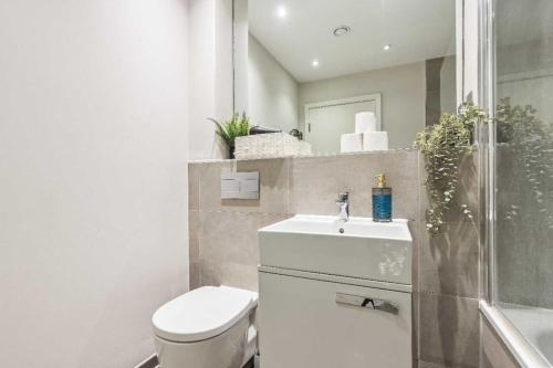 a bathroom with a toilet and a sink and a shower at Heathrow Retail Park Aprt Sleeps SEVEN Turbo WiFi in Sunbury Common