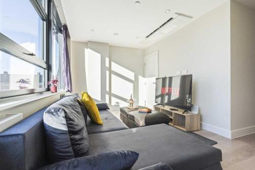 a living room with a couch and a tv at Heathrow Retail Park Aprt Sleeps SEVEN Turbo WiFi in Sunbury Common