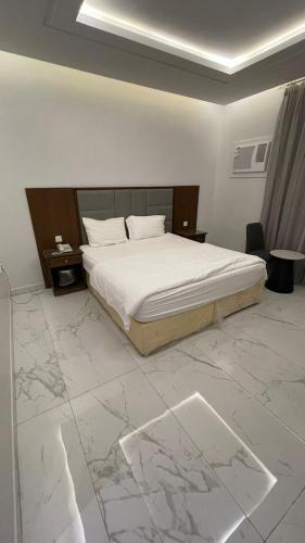 a bedroom with a large bed and a marble floor at شقق مخدومه in Ash Shafa