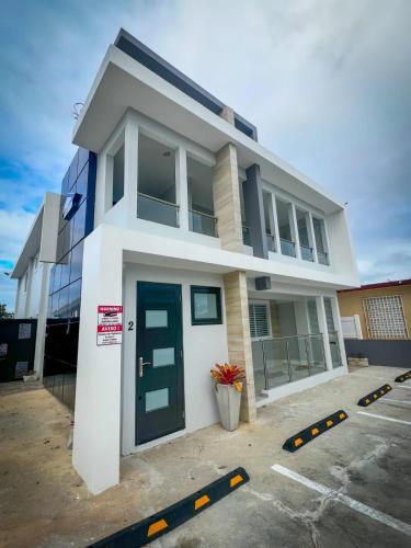 a white house with a blue door in a parking lot at Isabela Luxury Escape in Isabela