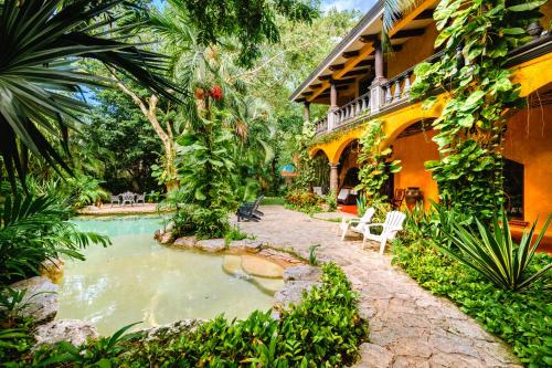 a house with a swimming pool next to a building at La Hacienda Hotel, at Xcaret in Playa del Carmen