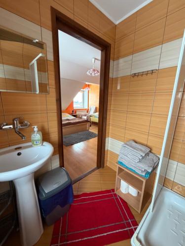 a small bathroom with a sink and a shower at Atticapartament in Kluszkowce