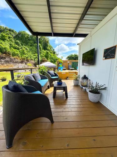 a patio with couches and a table on a wooden floor at Villa Morivivi Couples with pool in Tierras Nuevas Poniente