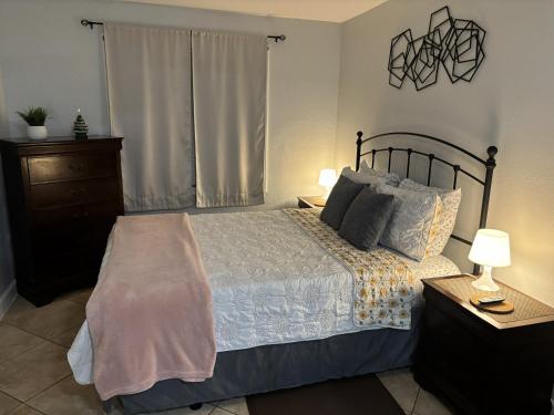 a bedroom with a bed and two lamps and a window at PRIVATE STUDIO near Busch Gardens & USF in Tampa