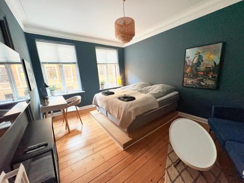 a bedroom with a bed and a living room at Greenbrook Blue Suite in Aalborg