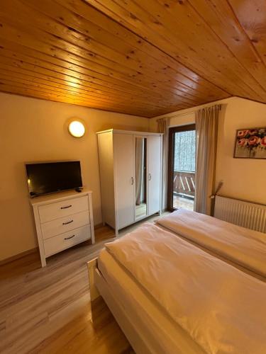 a bedroom with a large bed and a television at Casa de vacanta Mogosa in Baia-Sprie
