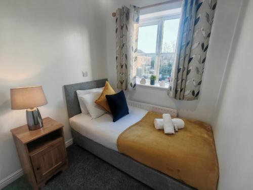 a small bedroom with a bed and a window at Park View House - Spacious 3 Bed Home in Burton in Burton upon Trent