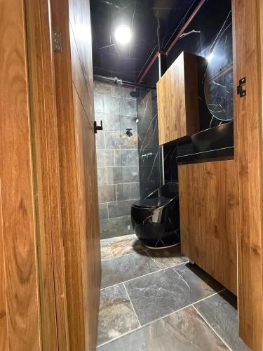 a bathroom with a black toilet and a shower at Casa ibague in Ibagué