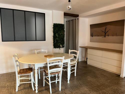La cachette chic ! في Sainte-Hélène-du-Lac: مطبخ وغرفة طعام مع طاولة وكراسي