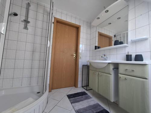 a bathroom with a tub and a sink and a shower at Piroska Pension in Olbernhau