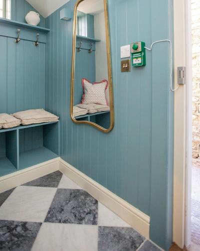 a bathroom with blue walls and a mirror at Luxurious Town Centre Apartments in Cirencester