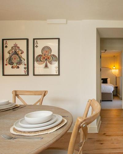 a dining room with a table with plates on it at Luxurious Town Centre Apartments in Cirencester