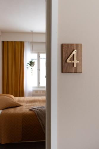 ein Schlafzimmer mit einem Bett und einem Schild mit der Zahl vier in der Unterkunft Guesthouse Terkkari in Lahti