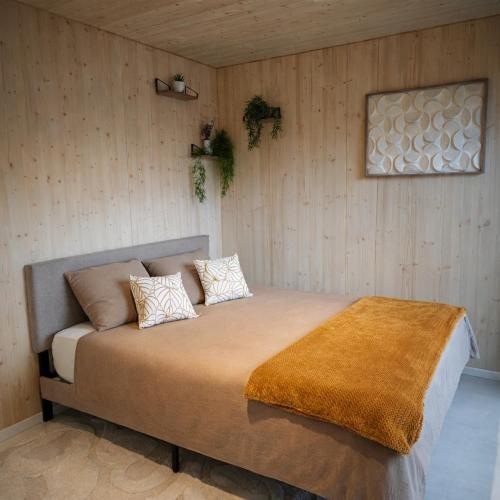 a bedroom with a large bed with two pillows at Tiny House Eole - Proche Issoudun, Safran, Rwe - Zone artisanale in Saint-Georges-sur-Arnon