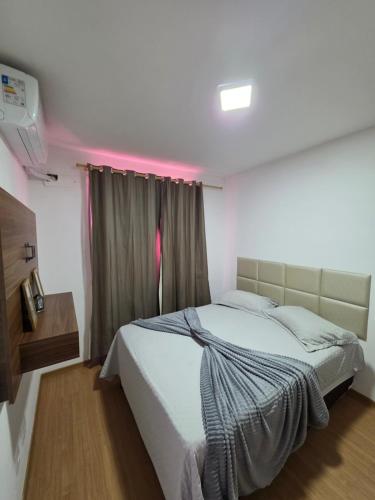 a bedroom with a white bed with a window at Torres dos Holandeses Vista Mar in São Luís