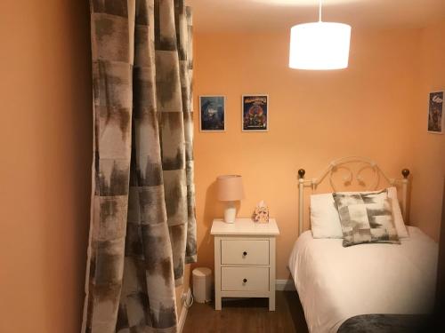 a bedroom with a bed and a table with a lamp at Bay Lodge Guest House in Eastbourne