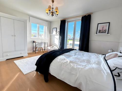 a bedroom with a bed and a large window at Luxe Villa Tramonto with jacuzzi in Sint-Truiden