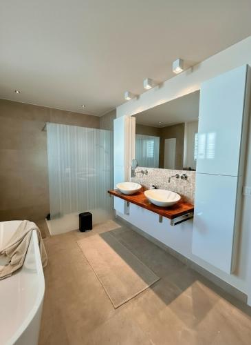a bathroom with two sinks and a large mirror at Luxe Villa Tramonto with jacuzzi in Sint-Truiden