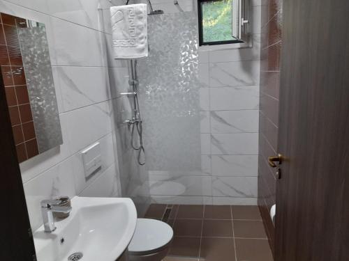 a bathroom with a sink and a toilet and a shower at Pensiune Restaurant Perla in Sângeorz-Băi