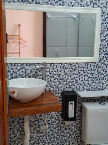a bathroom with a sink and a mirror and a toilet at Costamar Galinhos in Galinhos