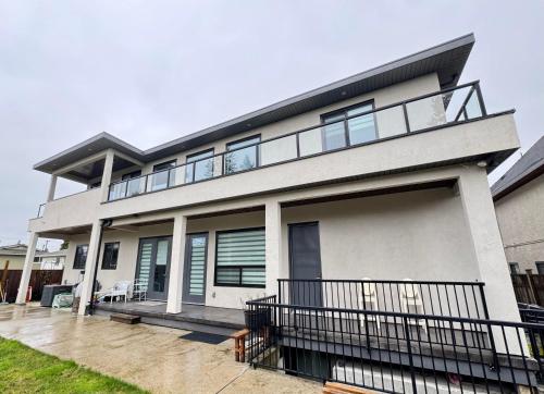 a large white house with a balcony at Excellent Place to Stay in Coquitlam