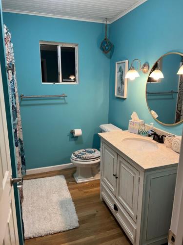 a blue bathroom with a sink and a mirror at Playing Hookie LLC in Dauphin Island