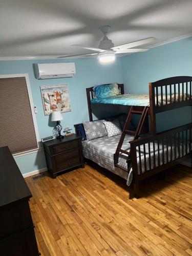 a bedroom with a bunk bed and a bed with a couch at Playing Hookie LLC in Dauphin Island