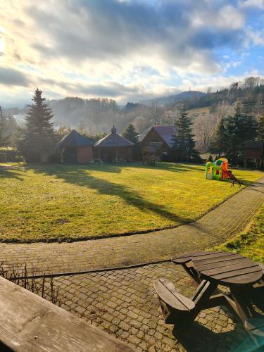a park with a picnic table and a playground at Całoroczne Domki "Stokrotka" in Solina