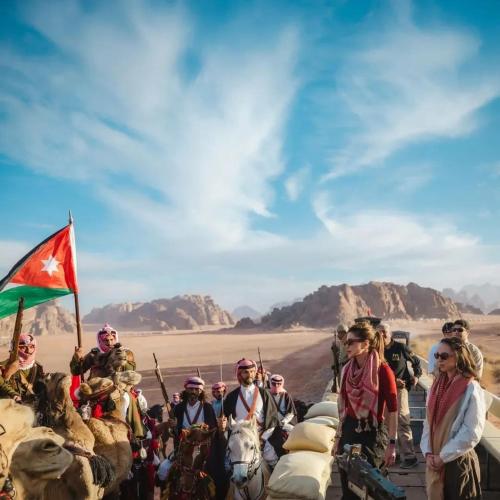 a group of people on camels in the desert at wadi rum luxe tours in Wadi Rum