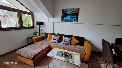a living room with a couch and a table at Time to RELAX apartment Mavrovo in Mavrovo